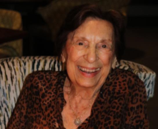 Elderly woman with a cheerful expression enjoys a moment of happiness at home.