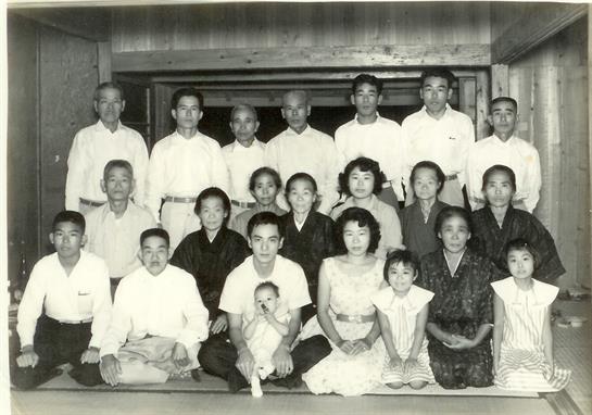 A large family poses together in traditional clothing, highlighting cultural heritage and unity.