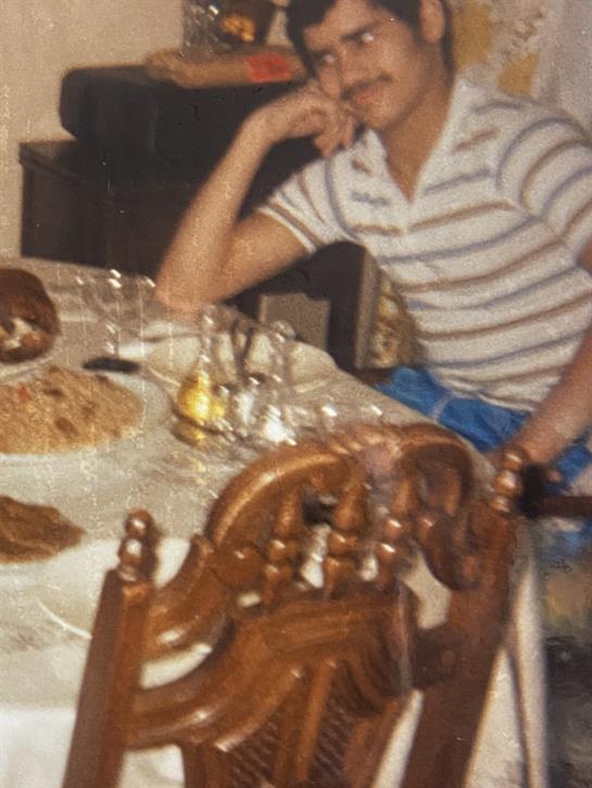 Friends enjoying a meal together at a wooden dining table filled with dishes and drinks.