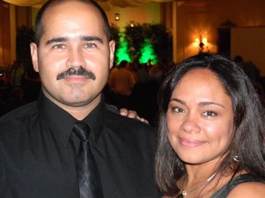 Two people smile warmly together at a classy evening celebration in an elegant setting.