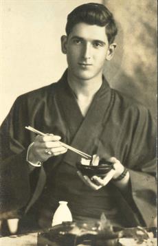 A person dressed in traditional attire gracefully eating sushi with chopsticks.