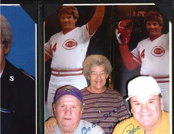 Fans happily pose with baseball memorabilia featuring players from past games.