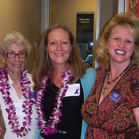 Participants enjoy a lively event, adorned in colorful leis and sharing smiles together.