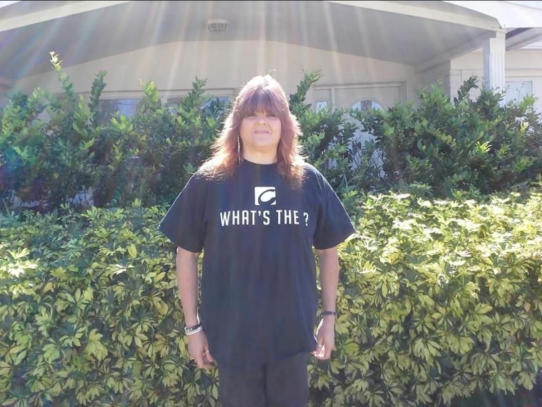 A person standing in front of a hedge
