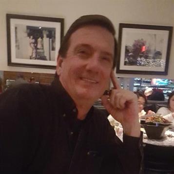 Group gathers at a restaurant table, enjoying food and conversation in a warm atmosphere.