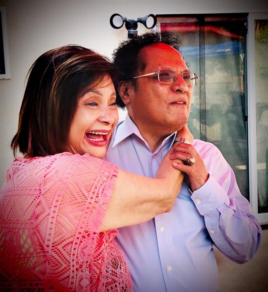 Two people share a joyful interaction in an outdoor setting, celebrating together with laughter.