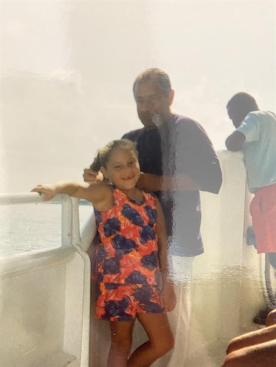 A cheerful girl enjoys time with her family on a boat, creating lasting summer memories together.
