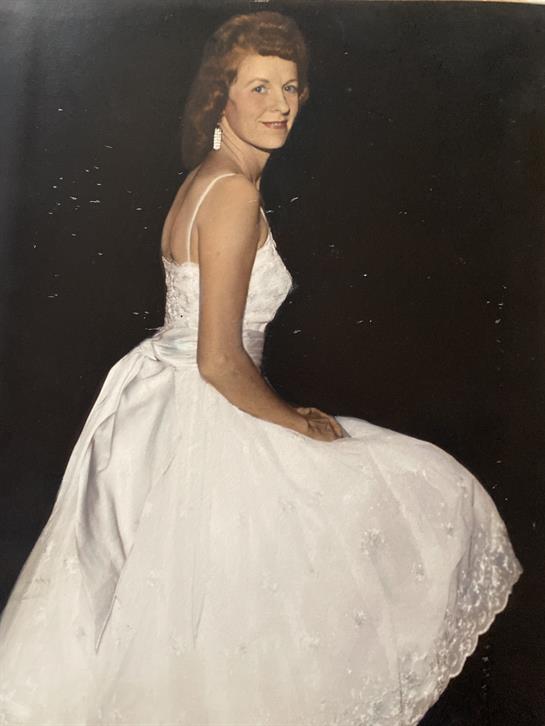 A bride joyfully poses in her beautiful white dress, capturing a moment of celebration.