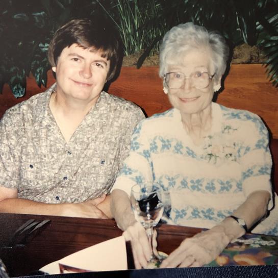 Two women enjoy each other's company at a restaurant, sharing smiles and laughter over dinner.
