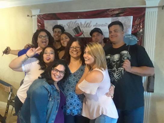 Friends are joyfully posing together at a casual indoor celebration with decorations.