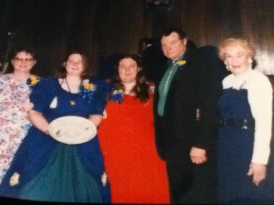 Group of five people in formal attire at a festive event, enjoying camaraderie and celebration.