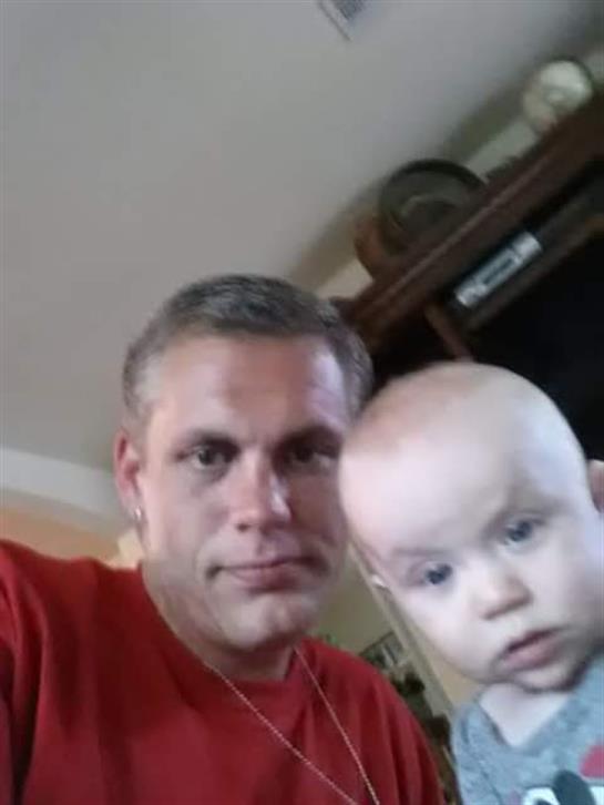 A parent and baby share a joyful moment indoors, showcasing their bond in a relaxed atmosphere.
