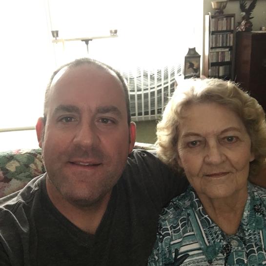 A man and woman enjoy a cheerful moment together in a warm, inviting living room filled with light.