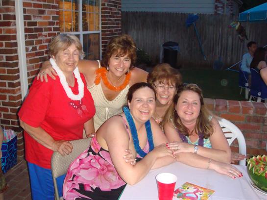 Five women enjoy each other's company while celebrating together in a backyard in summer.