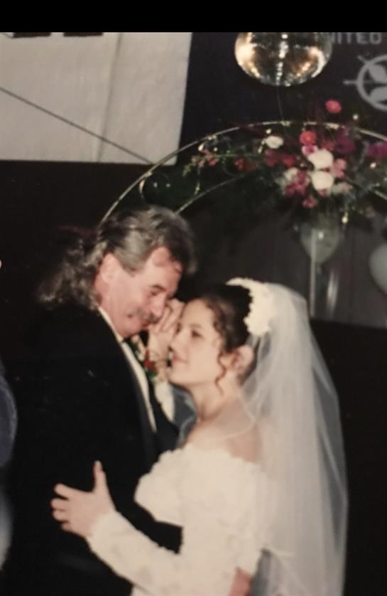 A happy couple shares a moment during their first dance, surrounded by beautiful decor.