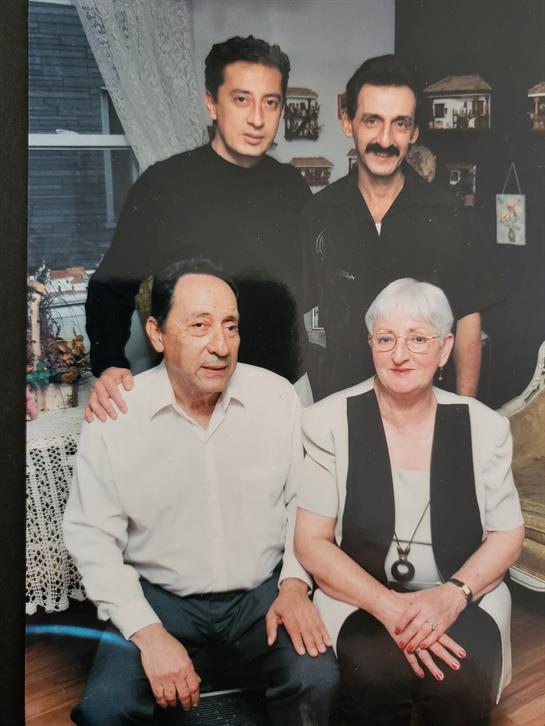 Four family members pose together happily in a warm and inviting living room setting.