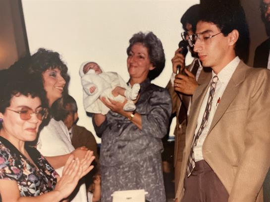 Relatives joyfully celebrate a newborn with smiles, clapping, and heartfelt emotions.