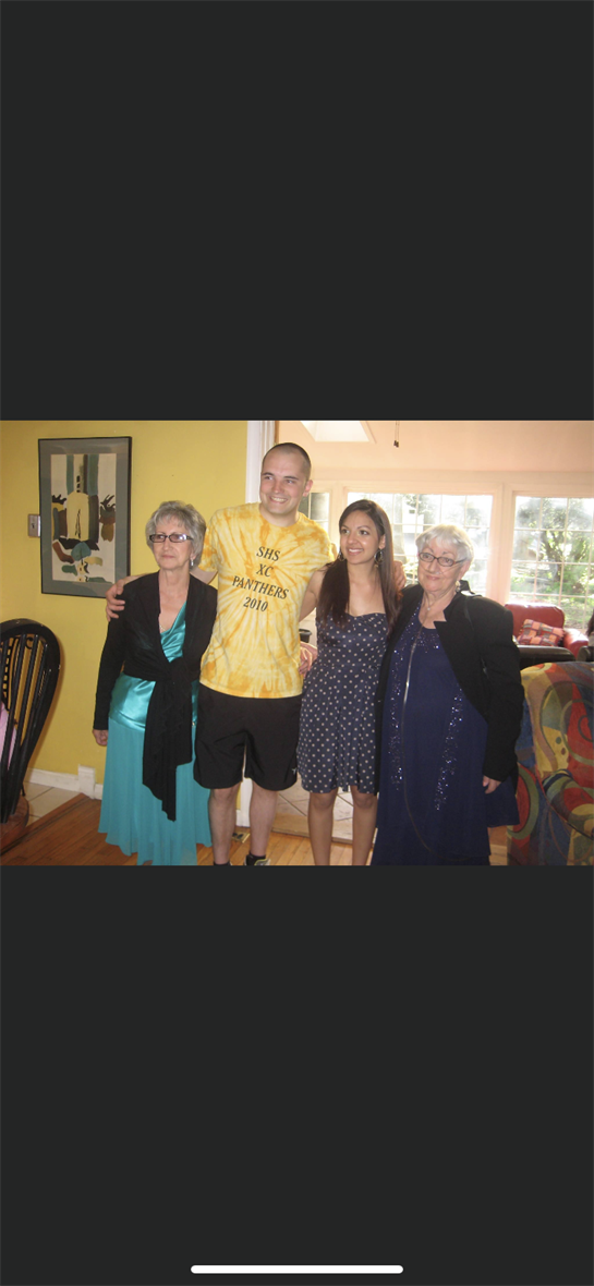 Four family members pose happily in their living room, showcasing close bonds during a gathering.
