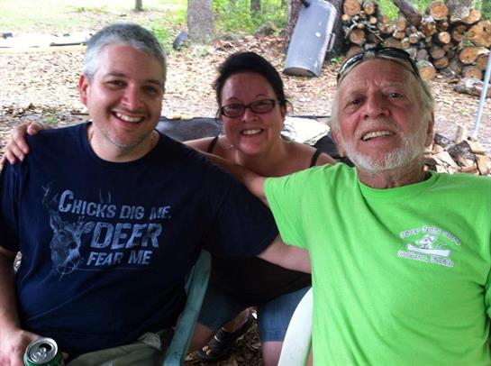 Three friends share laughter and smiles at a cozy backyard gathering.