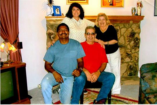 Four friends share smiles and laughter in a warm, welcoming living room setting.
