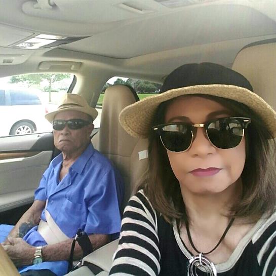 Two people are sitting inside a car, enjoying a sunny day on a road trip.