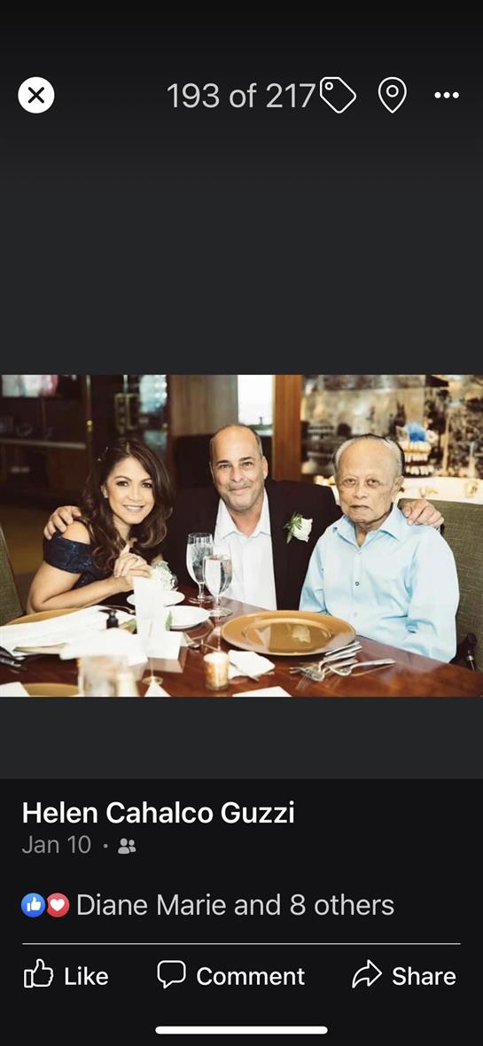 Three friends share laughter and conversation during a celebratory meal at a restaurant.