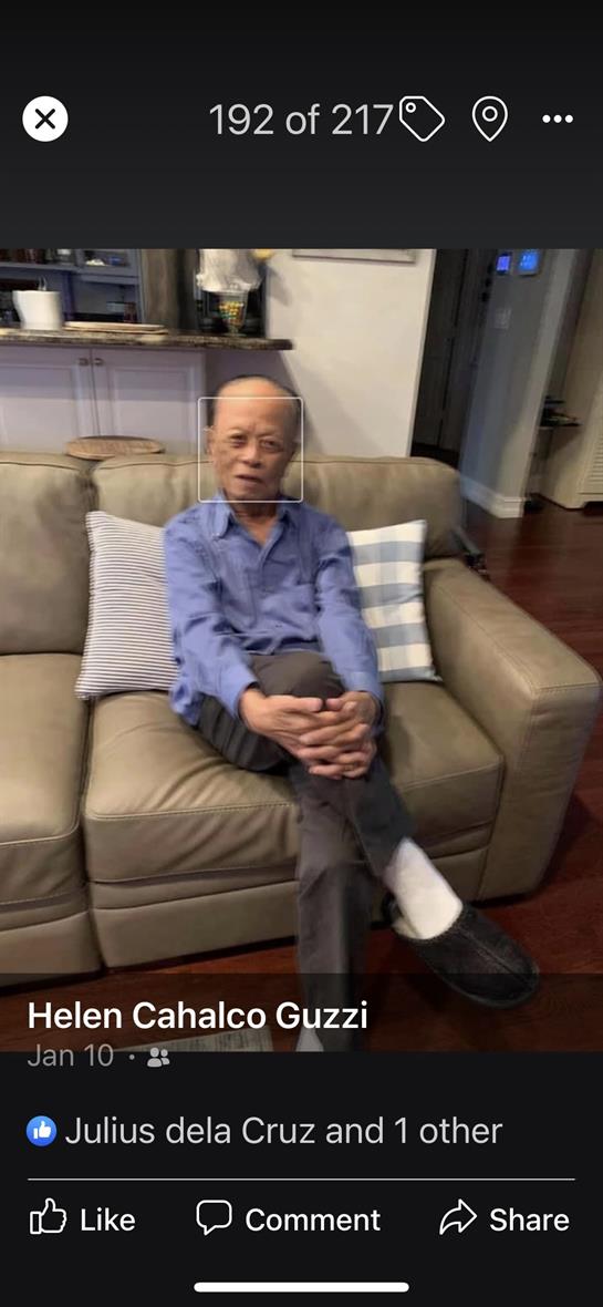An elderly man relaxes on a light-colored couch, enjoying his time in a homey setting.