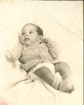 A sweet baby in a soft outfit explores the surroundings with curious eyes and a calm demeanor.