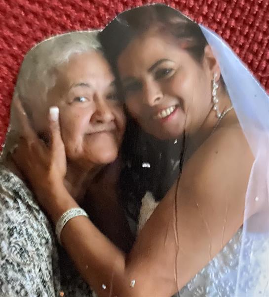 A bride in her wedding gown shares a loving embrace with her grandmother.