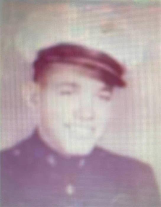 A young sailor in uniform smiles warmly, reflecting the pride of naval service from the 1960s.