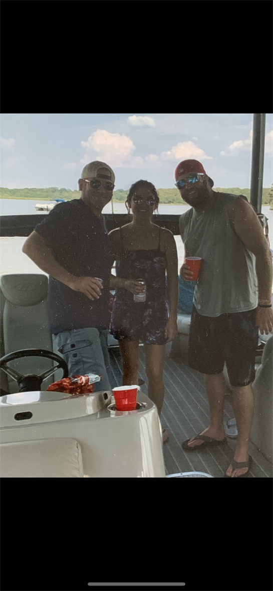 Three friends gather on a boat, sipping drinks and enjoying the sunny summer weather.