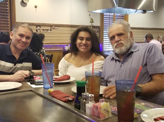 Friends enjoy drinks and food together at a bustling restaurant during lunch hour.