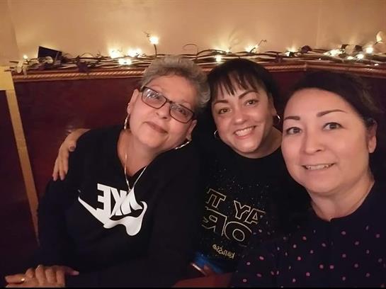 Friends enjoy a joyful moment together, sharing laughter and smiles in a warmly lit space.