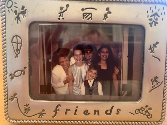 Five friends pose happily together in a decorated space, sharing laughter and good times.