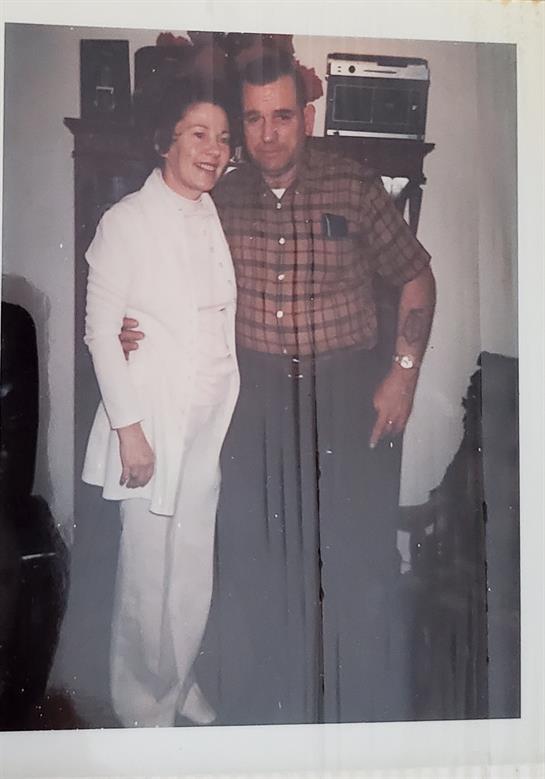 Couple sharing a joyful moment in a warmly decorated indoor space during an event.