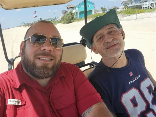 Two friends ride a golf cart on the beach, enjoying the sun and making memories.
