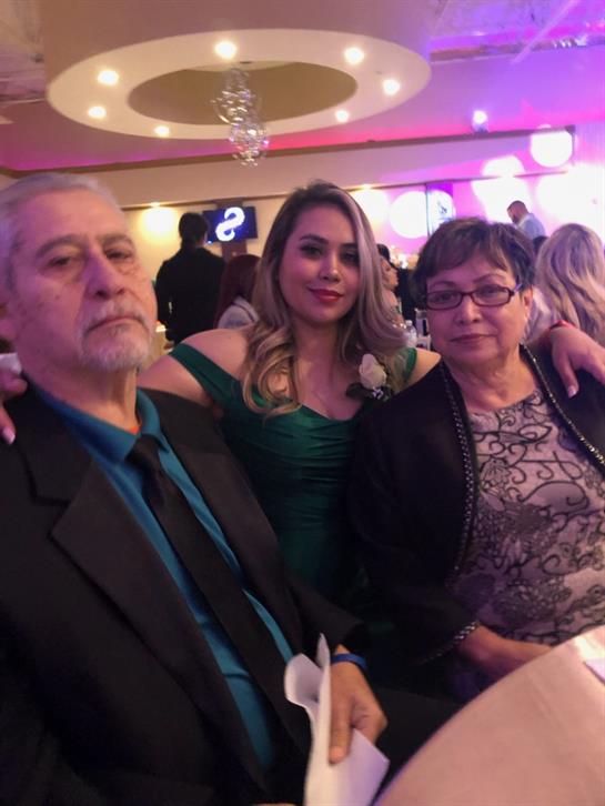 A family enjoys a celebratory event at a venue, posing together with smiles and festive attire.