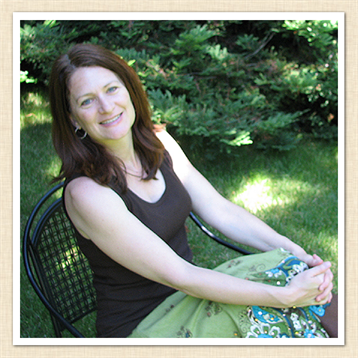 A woman relaxes in a green garden, seated comfortably on a chair, showcasing a warm smile.