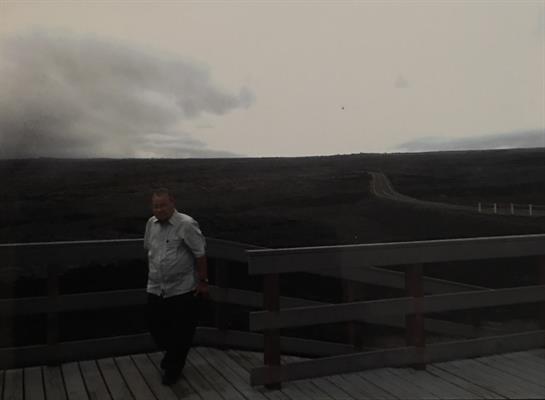 A person enjoys a peaceful evening walk on a deck, taking in the expansive view of rolling hills.