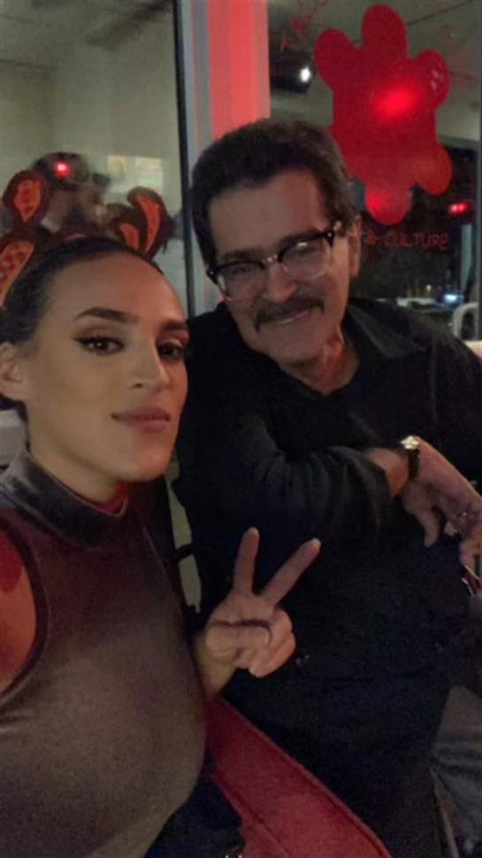 Two friends take a playful selfie while enjoying a vibrant celebration in the city.