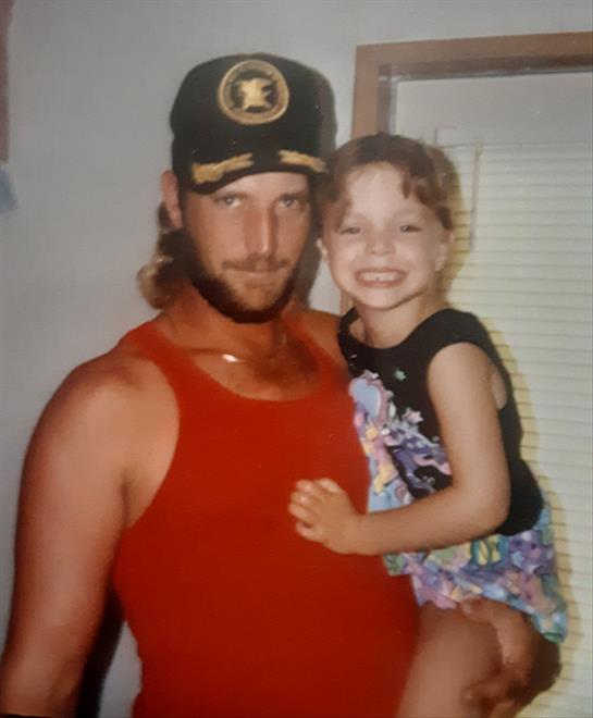 A smiling father and daughter share a joyful moment at home on a warm summer day.