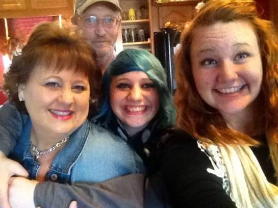 Four family members enjoy a joyful moment together in a warm kitchen filled with love.