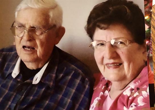 Elderly couple shares joyful moments together, conveying love and companionship at a family event.