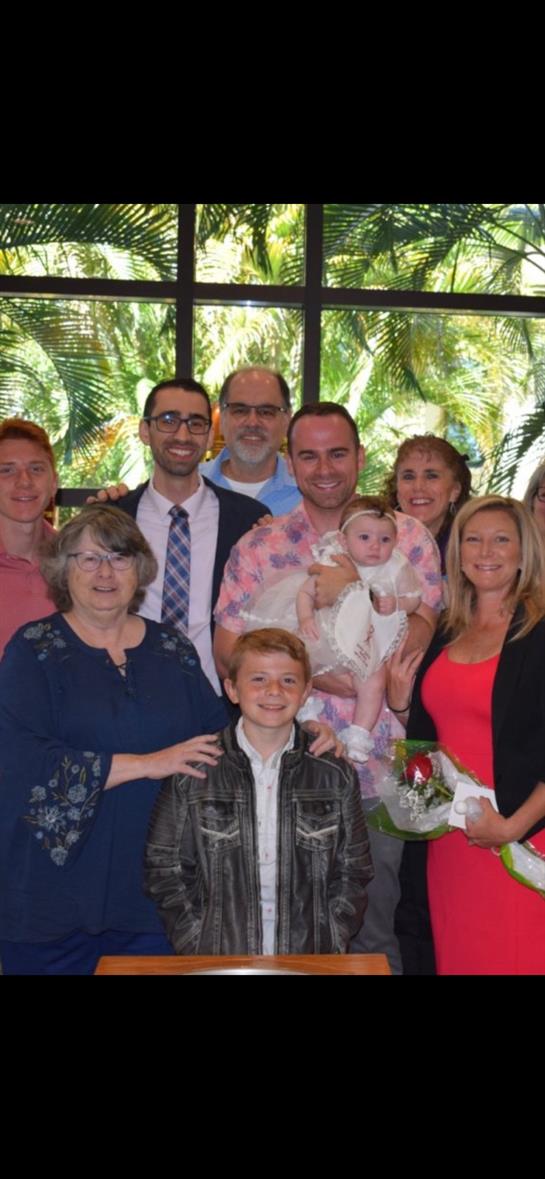 A joyful family gathering outdoors, surrounded by greenery, celebrating a milestone together.