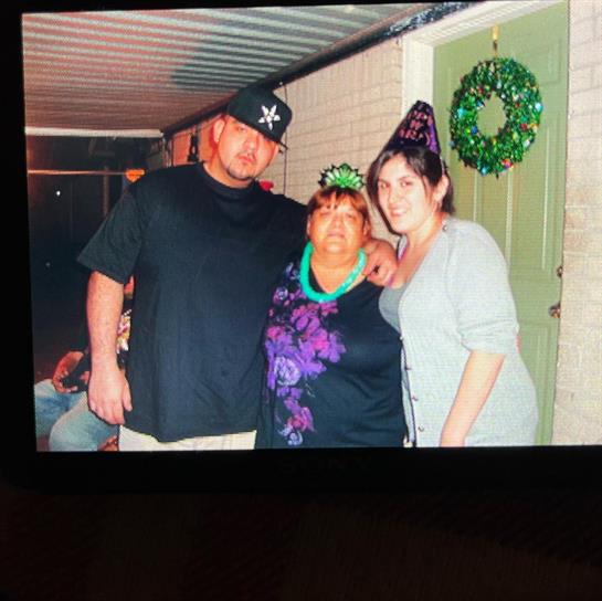 Family members gather for a joyful celebration, wearing festive attire and smiling warmly together.