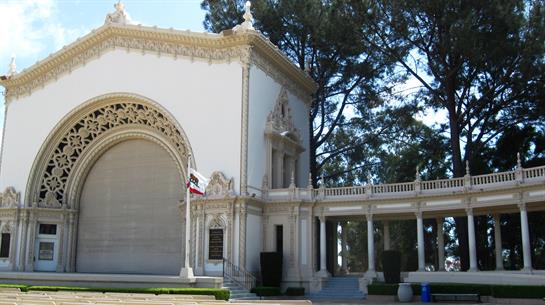 Visitors enjoy the stunning architecture of the historic building surrounded by tall trees.
