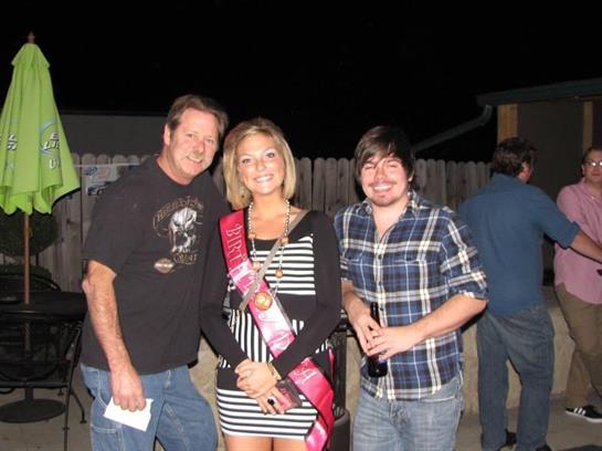 Three friends gather together during a nighttime celebration, enjoying the lively atmosphere.