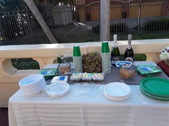 A table is set outdoors with snacks, drinks, and decorative items ready for guests.