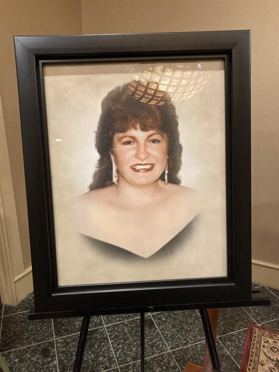 A woman in formal attire, with a chic hairstyle and earrings, exudes elegance.