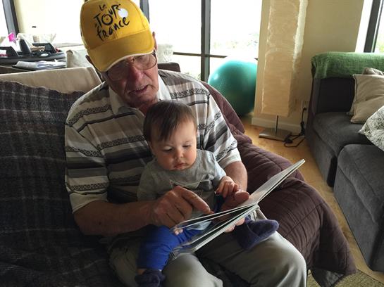 Grandfather shares a quiet moment with his grandson, reading together in a comfortable space.
